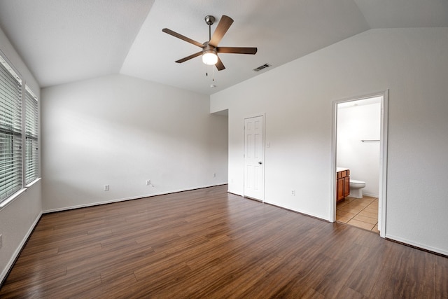 unfurnished bedroom with ceiling fan, vaulted ceiling, dark hardwood / wood-style floors, and ensuite bath