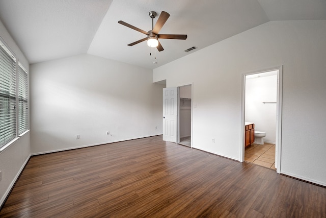 unfurnished bedroom with dark hardwood / wood-style flooring, vaulted ceiling, ceiling fan, and ensuite bath