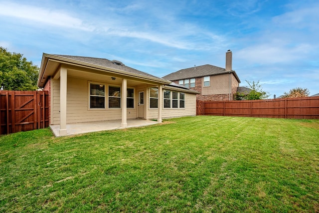 rear view of house with a yard and a patio