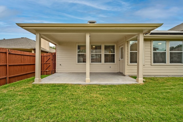 back of property with a patio area and a yard