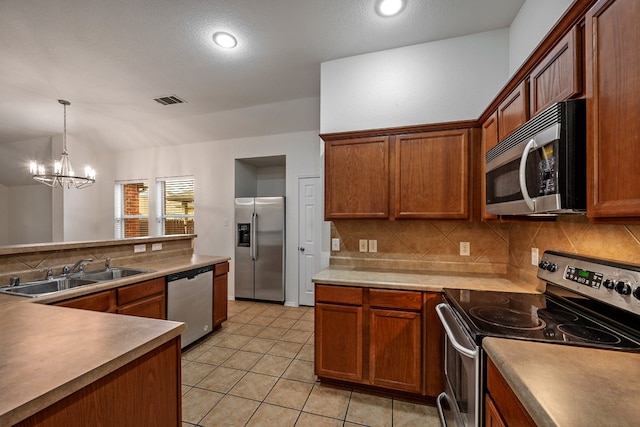 kitchen with stainless steel appliances, sink, light tile patterned floors, backsplash, and a notable chandelier