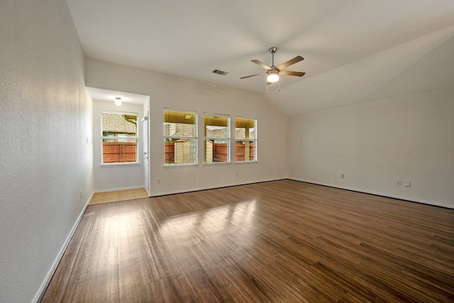 empty room with hardwood / wood-style flooring, ceiling fan, a healthy amount of sunlight, and lofted ceiling