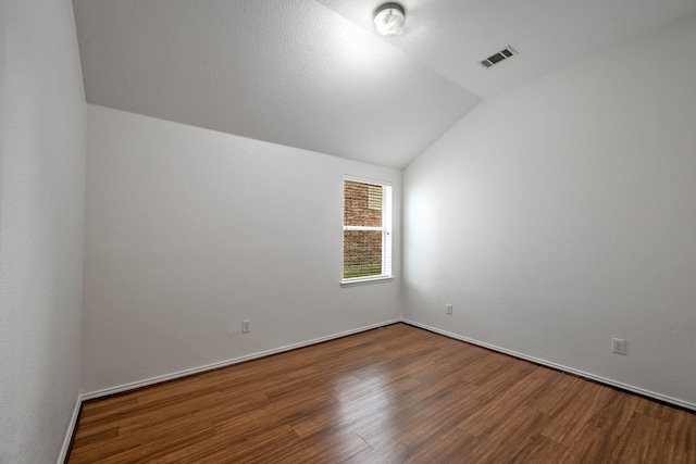 empty room with hardwood / wood-style floors and lofted ceiling