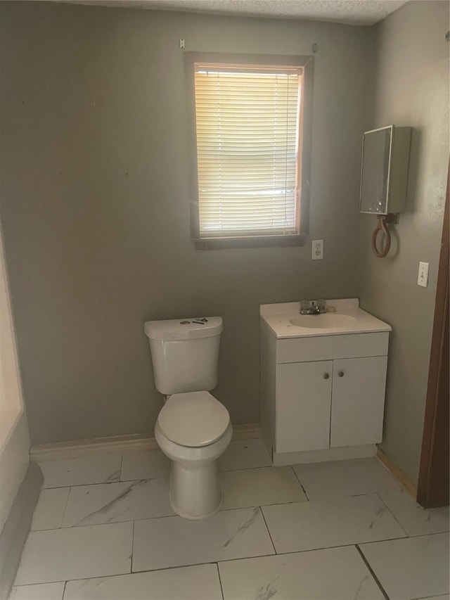 bathroom with vanity, toilet, and a textured ceiling