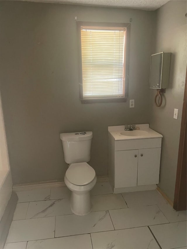 844 1st St SW, Paris, TX 75460 - half bathroom with marble look tile flooring, toilet, and baseboards