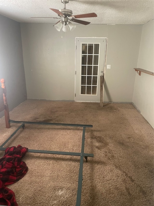 unfurnished room with carpet, a textured ceiling, and ceiling fan