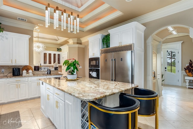 kitchen with black appliances, decorative light fixtures, decorative backsplash, an inviting chandelier, and a center island