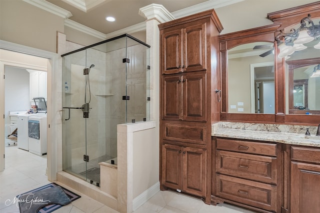 bathroom featuring washing machine and dryer, crown molding, vanity, and a shower with shower door