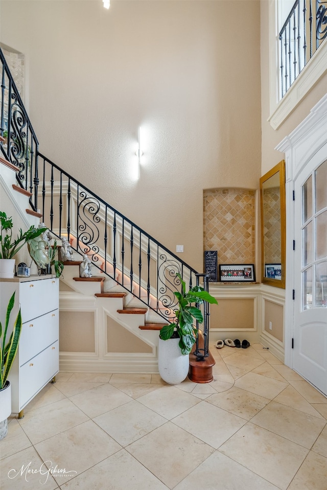 tiled entryway featuring a high ceiling