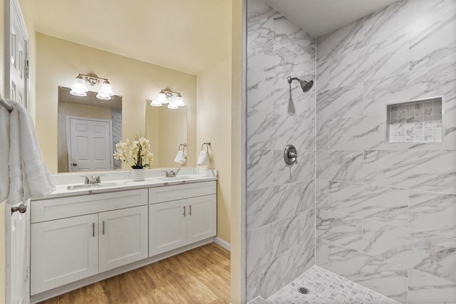 bathroom featuring vanity, hardwood / wood-style floors, and tiled shower