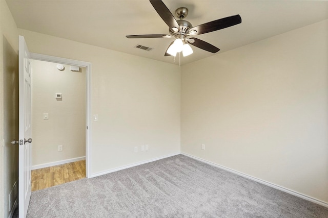 spare room featuring light carpet and ceiling fan