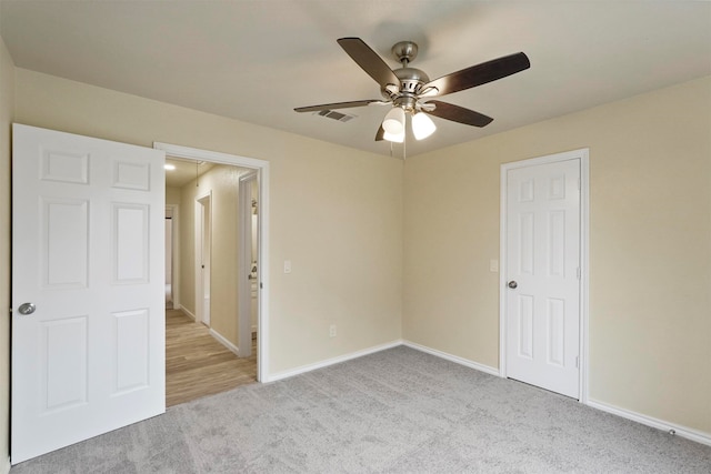 unfurnished bedroom featuring light colored carpet and ceiling fan