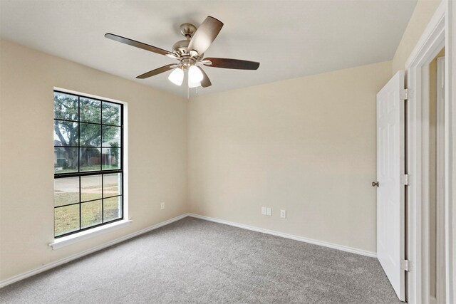 carpeted spare room with ceiling fan