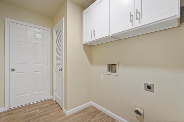 clothes washing area featuring hookup for an electric dryer, light hardwood / wood-style floors, hookup for a washing machine, and cabinets