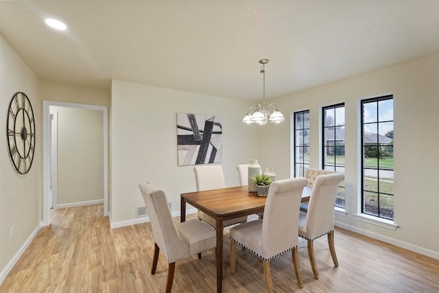 dining room featuring an inviting chandelier, plenty of natural light, and light hardwood / wood-style flooring