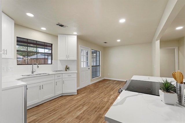 kitchen featuring white cabinetry, sink, and light hardwood / wood-style flooring