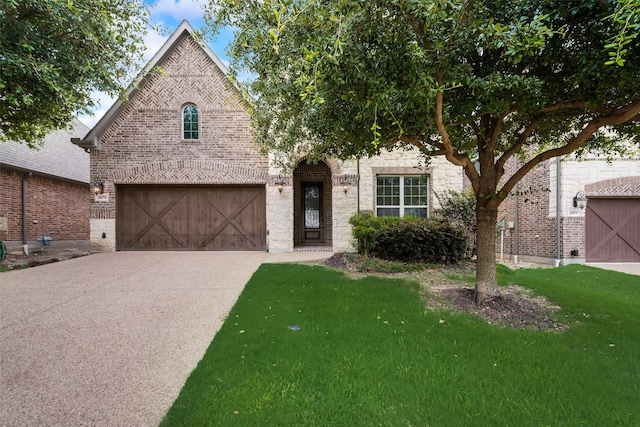 tudor-style house with a garage and a front yard