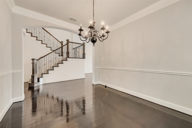 unfurnished dining area with ornamental molding, dark hardwood / wood-style flooring, and an inviting chandelier