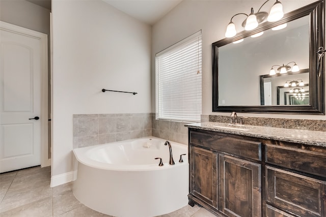 bathroom with a washtub, vanity, tile patterned floors, and a healthy amount of sunlight