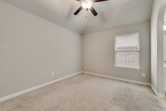 carpeted spare room featuring ceiling fan and vaulted ceiling