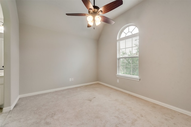 unfurnished room featuring vaulted ceiling, light colored carpet, ceiling fan, and plenty of natural light