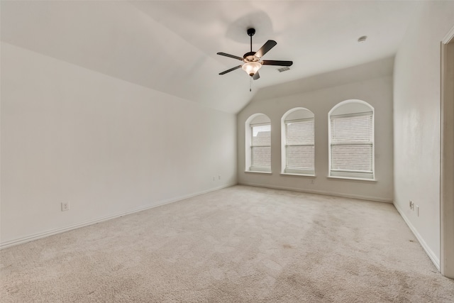 empty room with vaulted ceiling, light carpet, and ceiling fan