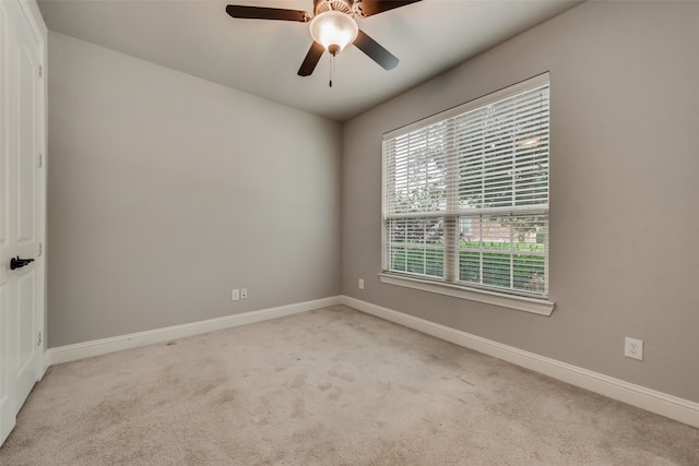 spare room with light colored carpet and ceiling fan