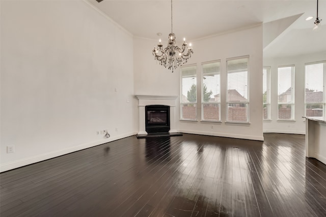 unfurnished living room featuring dark wood-type flooring, crown molding, and an inviting chandelier