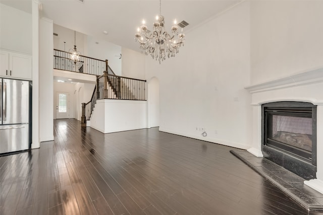 unfurnished living room with a high ceiling, dark hardwood / wood-style floors, and crown molding