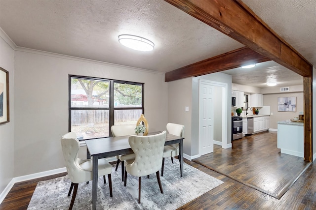 dining room featuring beamed ceiling, dark hardwood / wood-style floors, and a textured ceiling