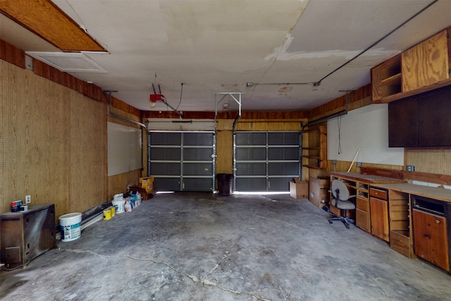 garage with wooden walls and a garage door opener