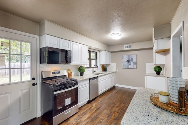 kitchen with dark wood-type flooring, appliances with stainless steel finishes, sink, and white cabinets