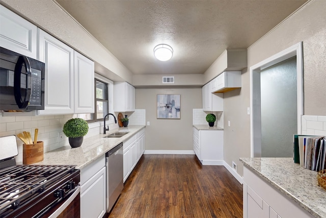 kitchen with gas stove, dark hardwood / wood-style flooring, sink, white cabinets, and dishwasher