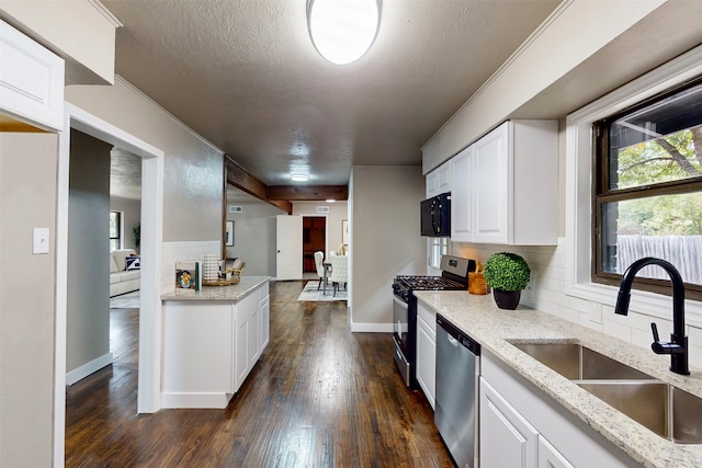 kitchen featuring dark hardwood / wood-style flooring, decorative backsplash, a textured ceiling, sink, and appliances with stainless steel finishes