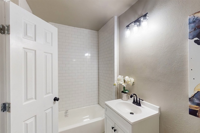 bathroom with tiled shower / bath and vanity