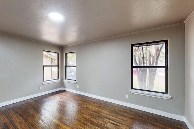 empty room with dark hardwood / wood-style flooring, a textured ceiling, and ornamental molding