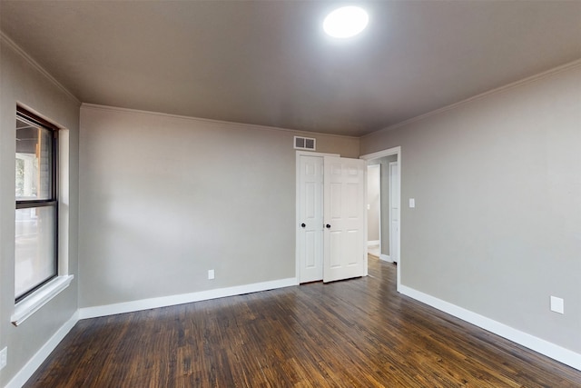 empty room featuring ornamental molding and dark hardwood / wood-style floors