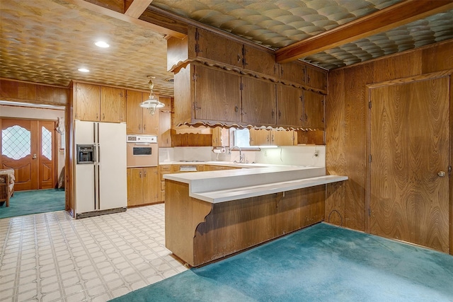 kitchen featuring light carpet, sink, kitchen peninsula, white appliances, and pendant lighting