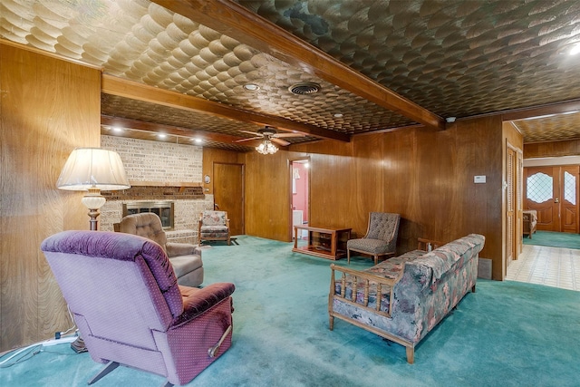 living room with a brick fireplace, wooden walls, and beamed ceiling