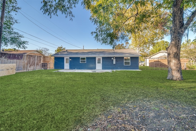 rear view of property with a yard and a patio