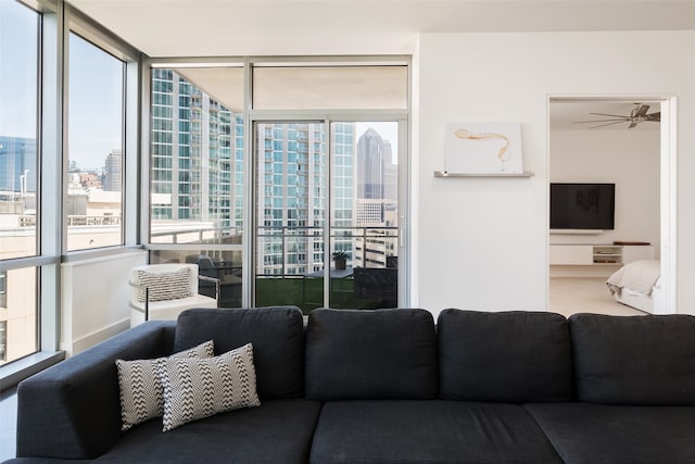 living room with expansive windows and ceiling fan