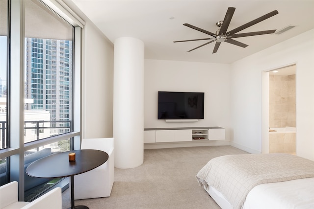 bedroom featuring light carpet, ceiling fan, and ensuite bathroom