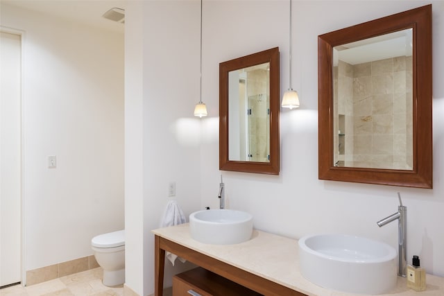 bathroom with toilet, vanity, and tile patterned floors