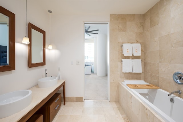 bathroom featuring tile walls, sink, tile patterned flooring, a relaxing tiled tub, and ceiling fan