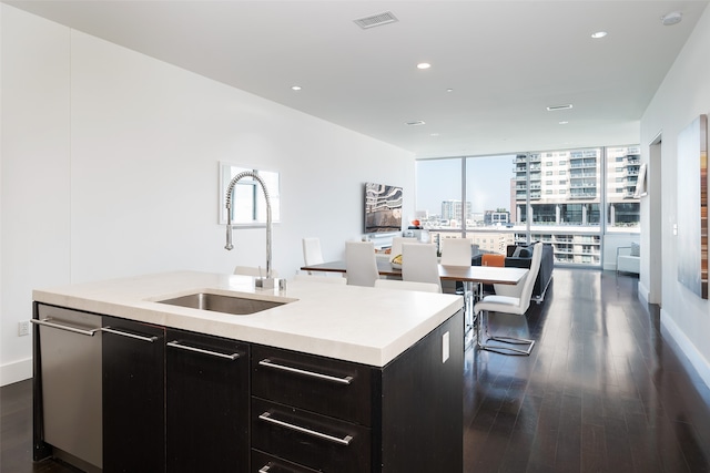 kitchen with dark hardwood / wood-style flooring, sink, a center island with sink, and a wall of windows