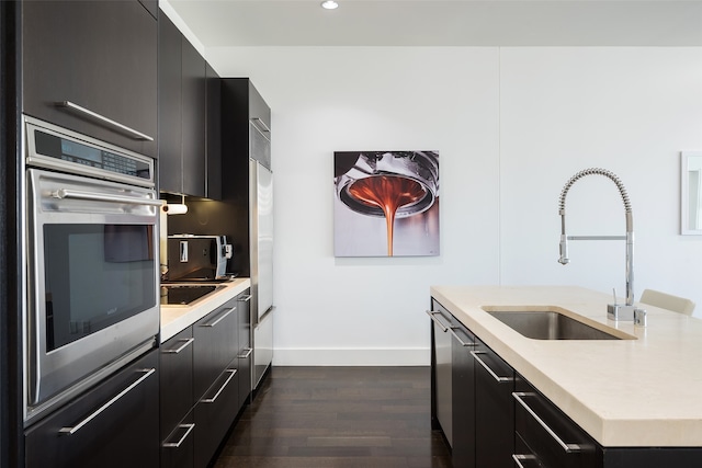 kitchen featuring oven, sink, black electric stovetop, and dark hardwood / wood-style flooring