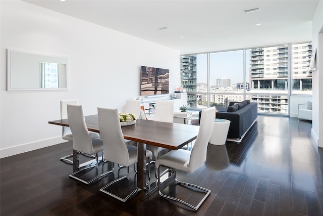 dining room with a wall of windows and dark hardwood / wood-style floors