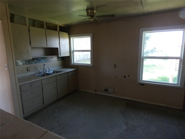 kitchen featuring ceiling fan, plenty of natural light, and sink