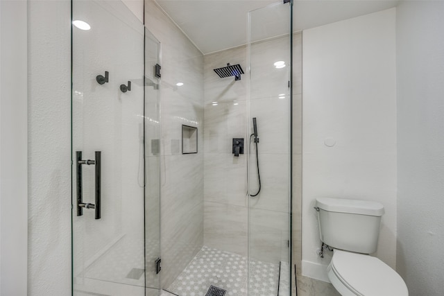 bathroom with toilet and a shower with door