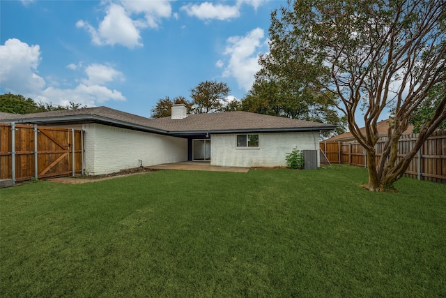 rear view of house with a patio area, a yard, and central air condition unit